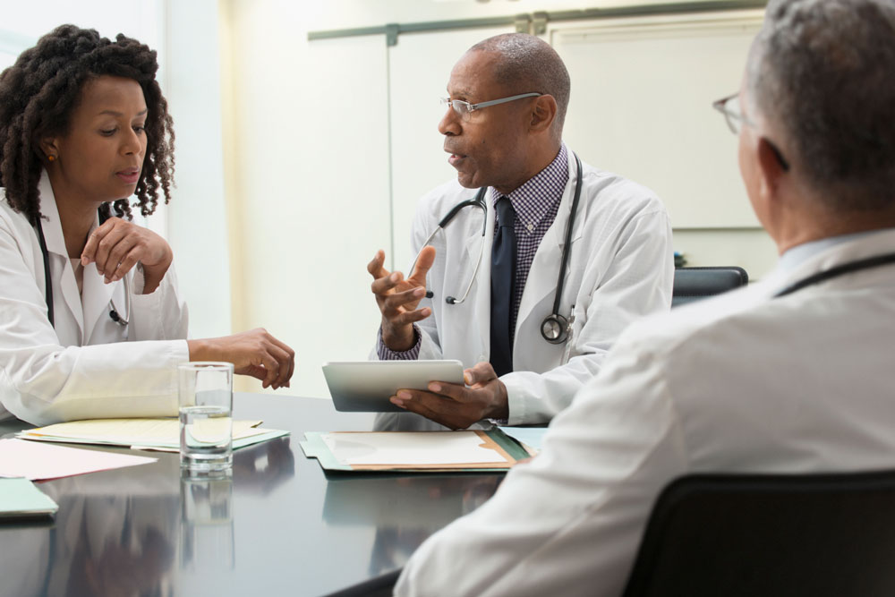 Medical professionals talking while sitting at a table